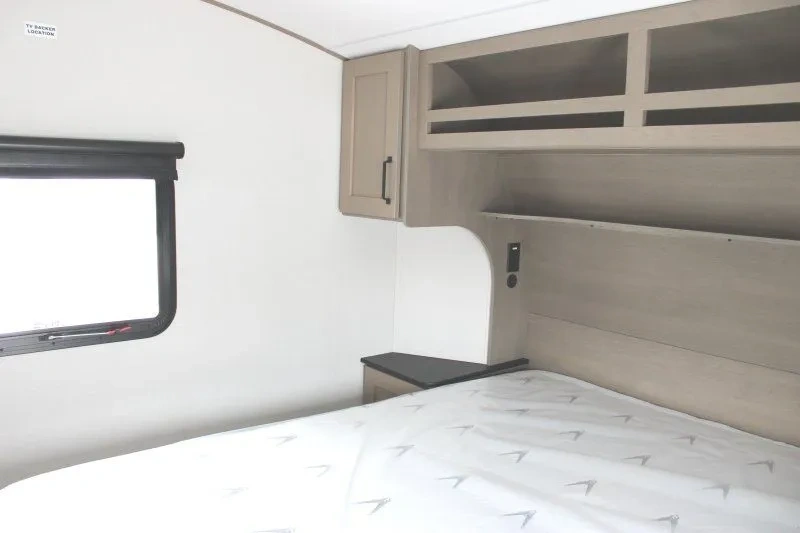 Chambre du Grand Design Reflection 100 Series 22RK avec rangement suspendu.