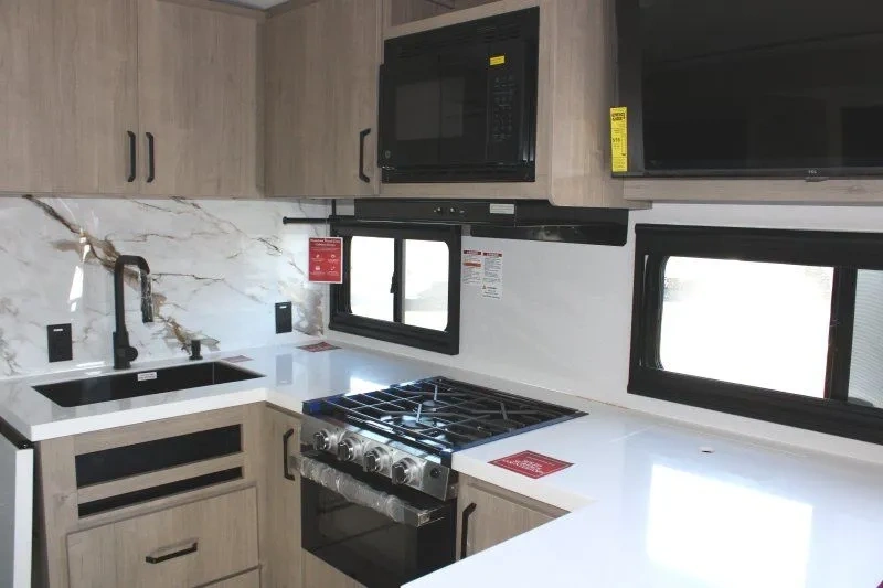 Cuisine de la Grand Design Imagine 2470BH avec comptoir et cuisinière.