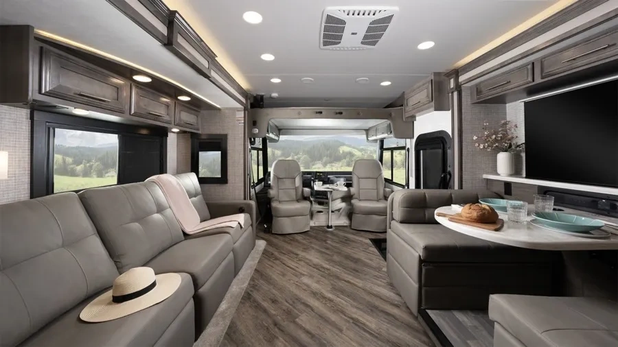 Intérieur luxueux de l’Entegra Coach Emblem avec salon, cuisine et poste de conduite.