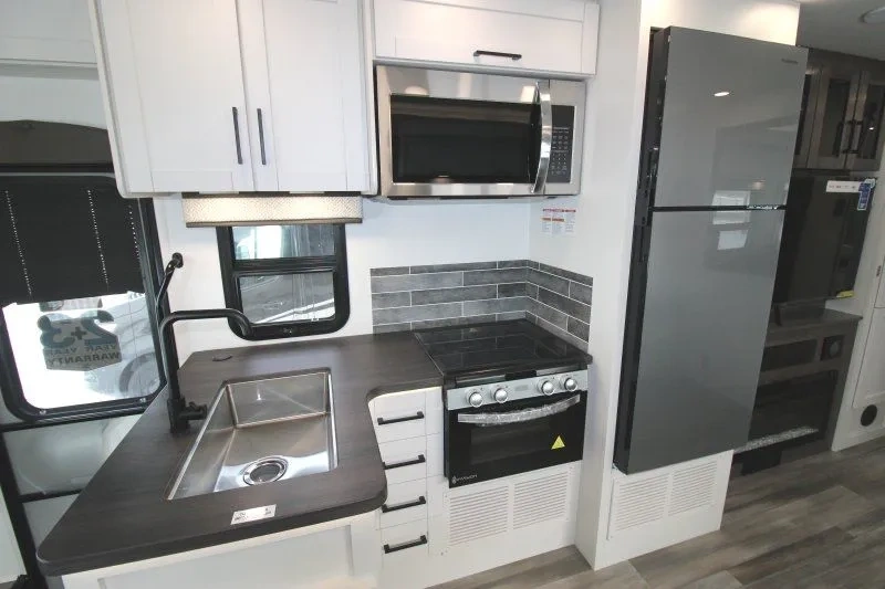 Cuisine du Jayco Greyhawk 30Z avec armoires blanches et cuisinière.