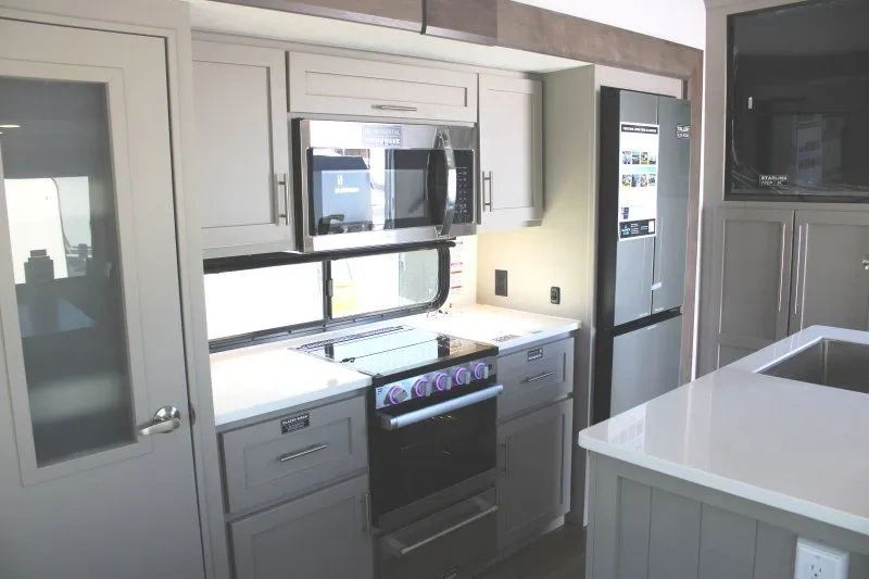 Cuisine du Alliance Avenue All-Access 25RL avec cuisinière, micro-ondes et armoires.