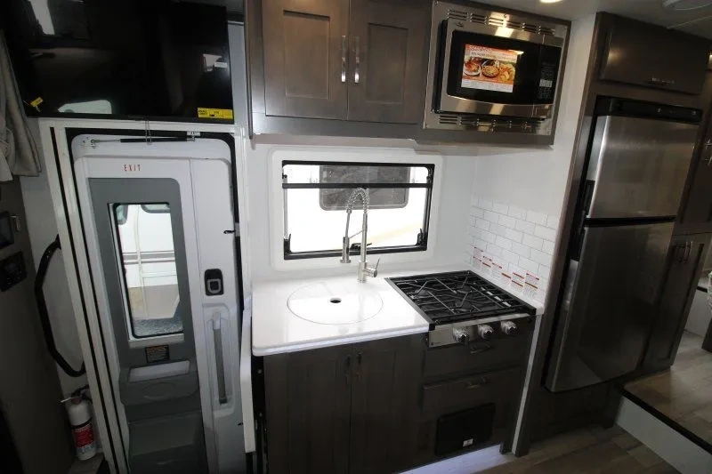 Cuisine du Dynamax Isata 3 24RW avec évier et cuisinière.