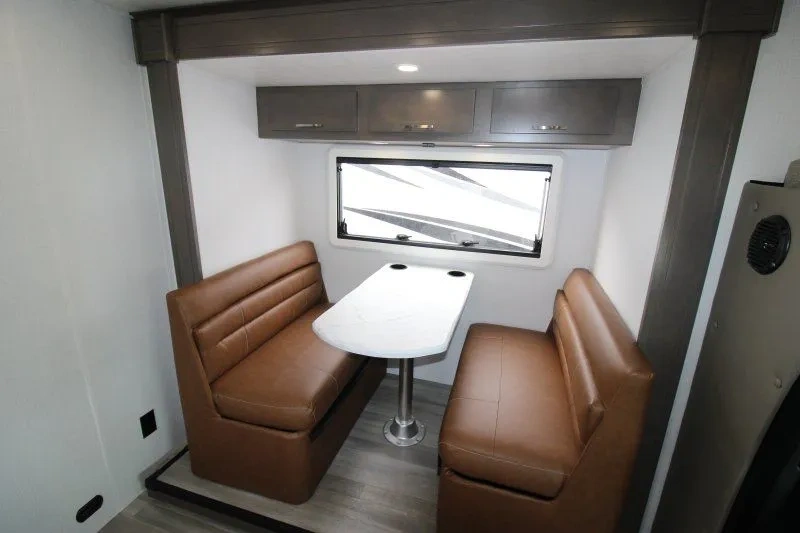Dinette du Dynamax Isata 3 24RW avec banquettes brunes.