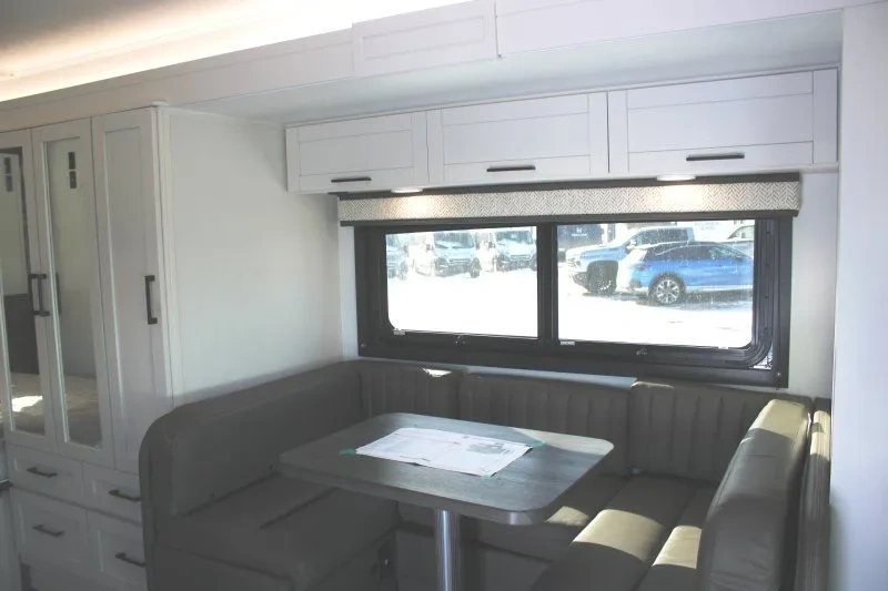 Dinette en U de l’Entegra Coach Odyssey 24B près de la grande fenêtre.