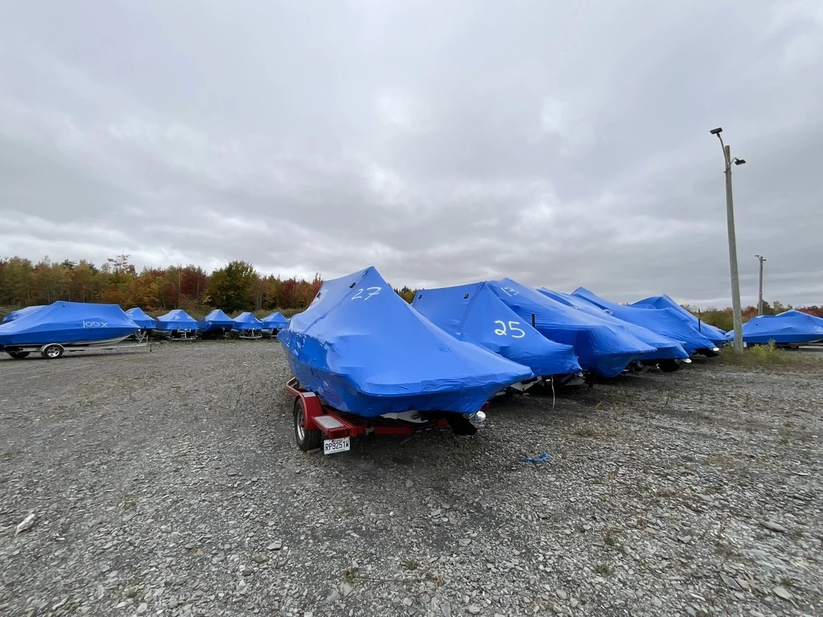 Boats under blue protective covers on trailers at Estrie Marine in Sherbrooke.