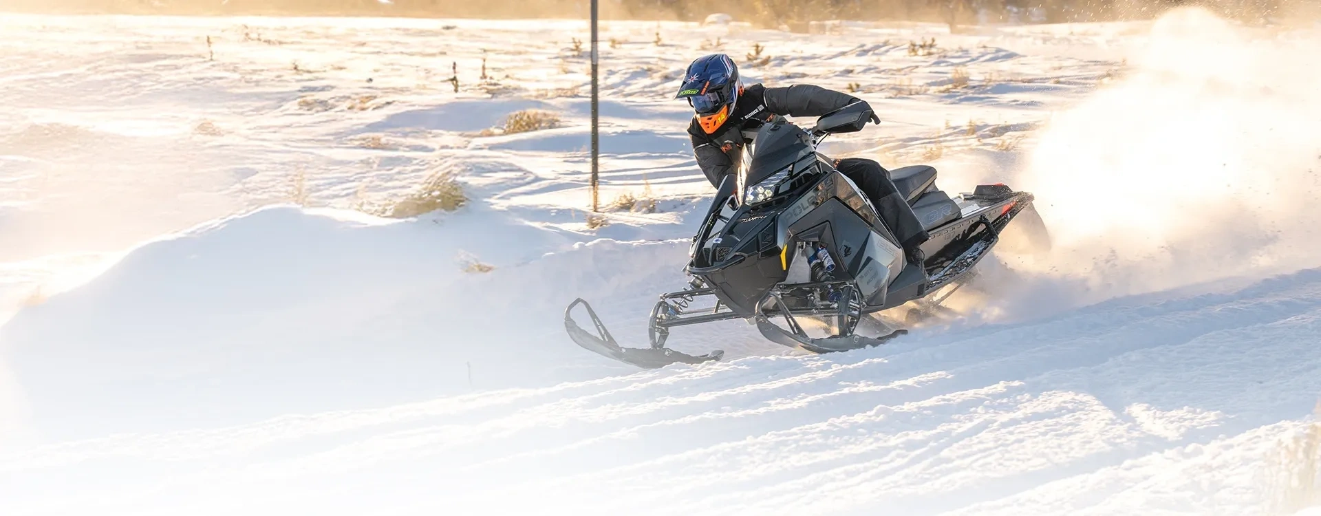 Polaris INDY XCR 2027 négociant un virage sur la neige avec son conducteur incliné.