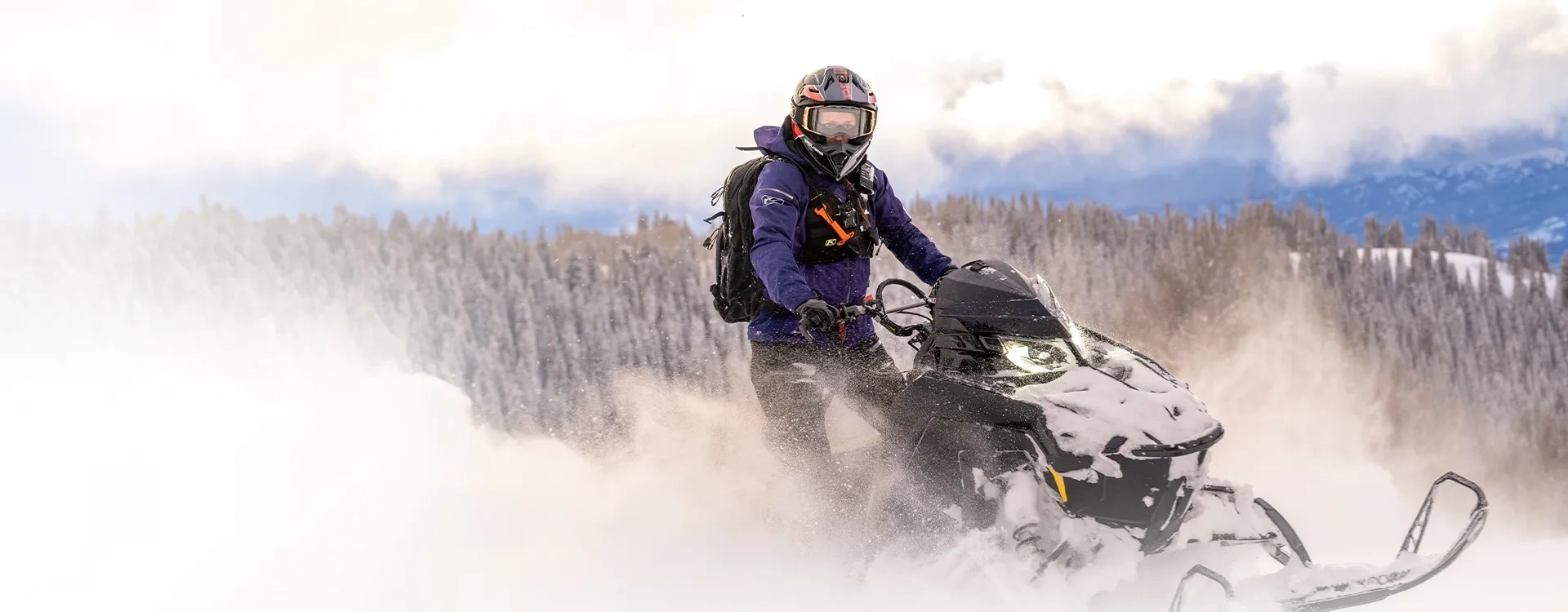 Polaris RMK SPS 850 155 2027 pilotée debout dans la neige profonde pour une sortie hors-piste.