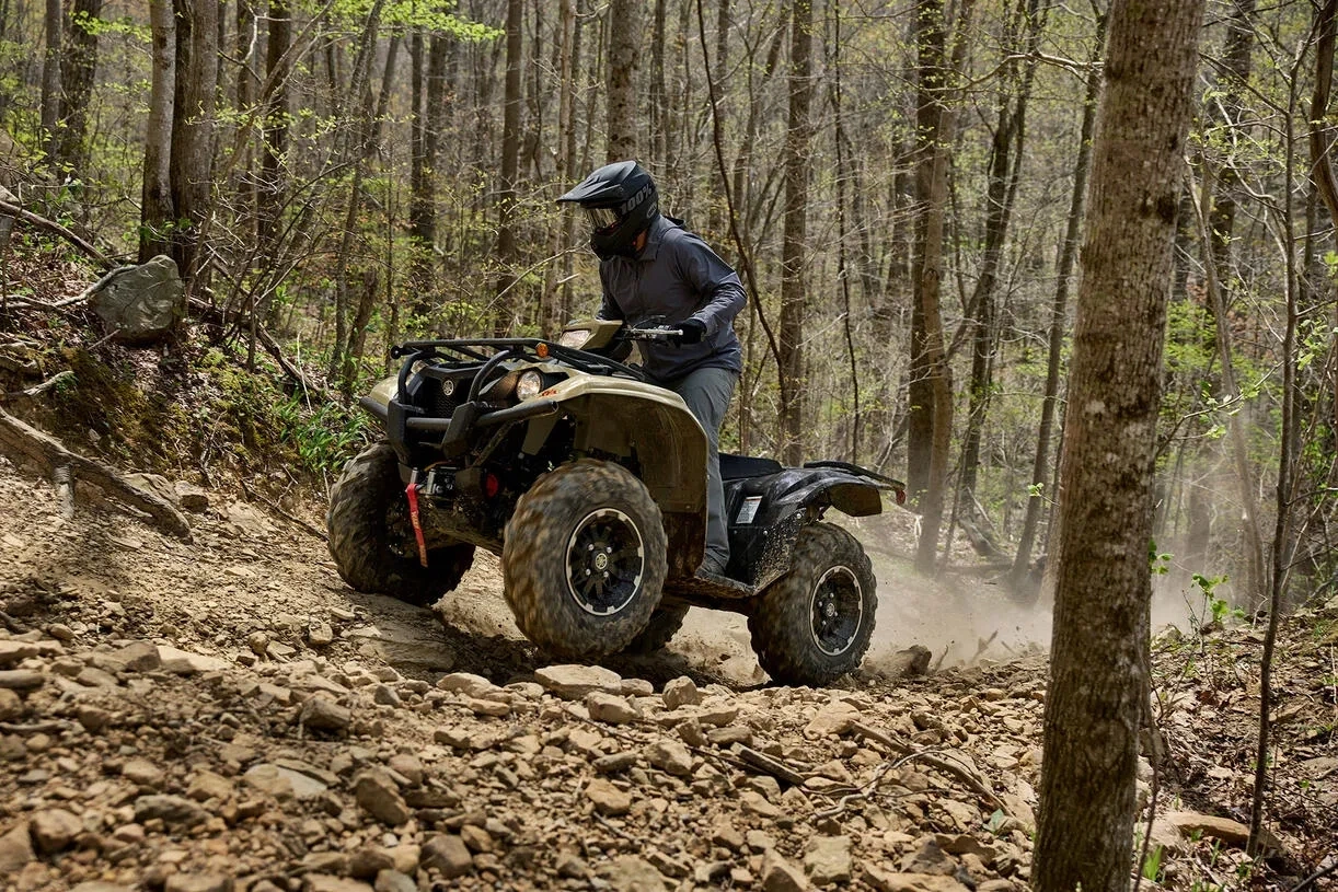 VTT Yamaha Kodiak 700 en randonnée sur un sentier boisé.