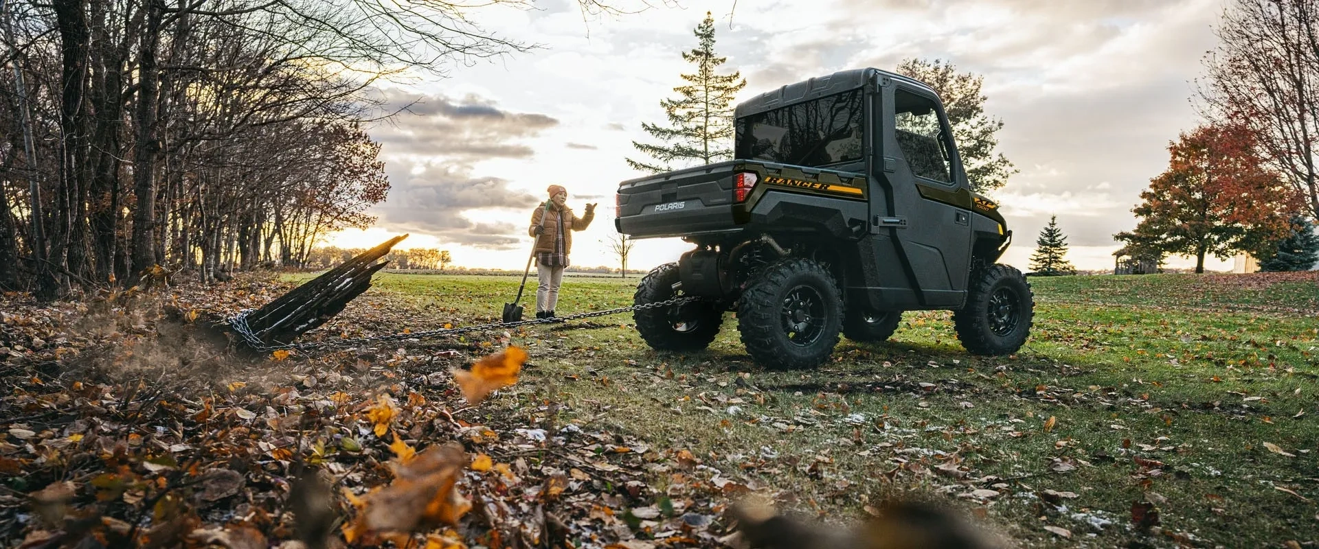 Polaris RANGER XP 1000 CAB 2027 vu de trois quarts arrière sur une propriété en automne.