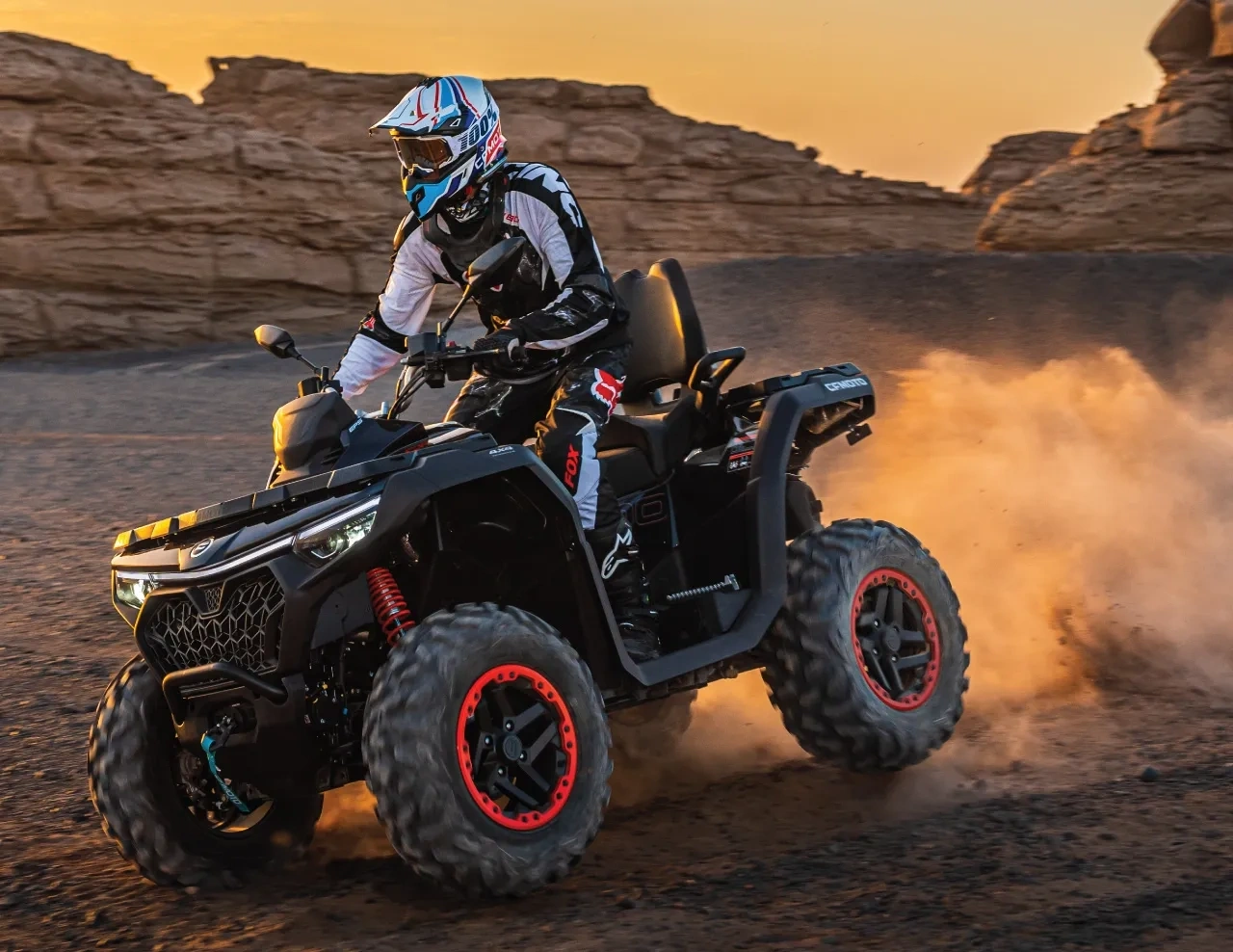 Rider on a 2027 CFMOTO CFORCE 1000 TOURING ATV travelling across rocky and dusty terrain.