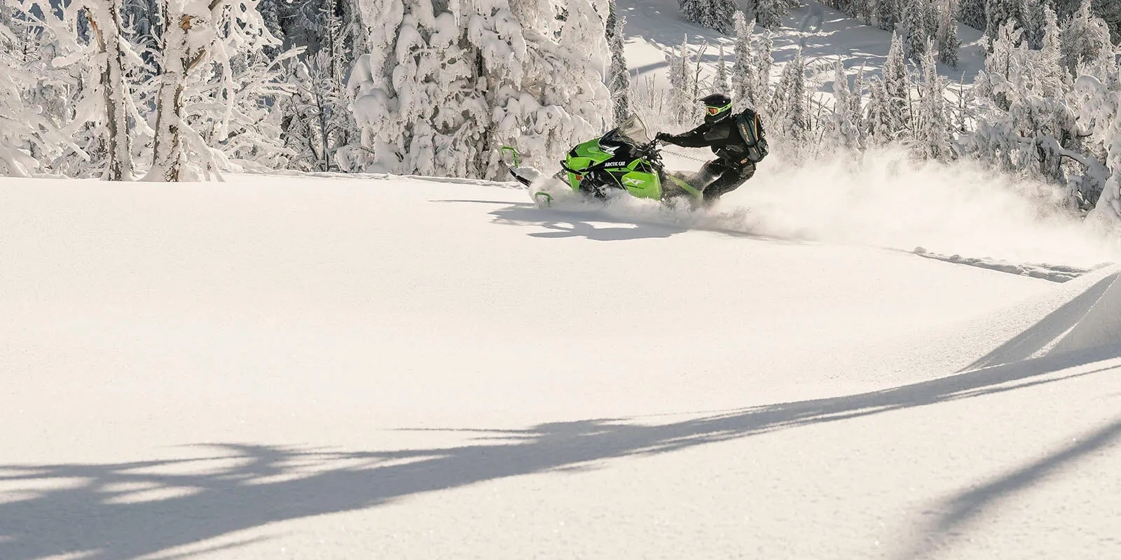 2027 Arctic Cat XF 858 crossover snowmobile cornering through powder in a forest.