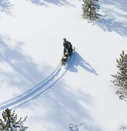 Polaris INDY Adventure snowmobile on a snowy trail.