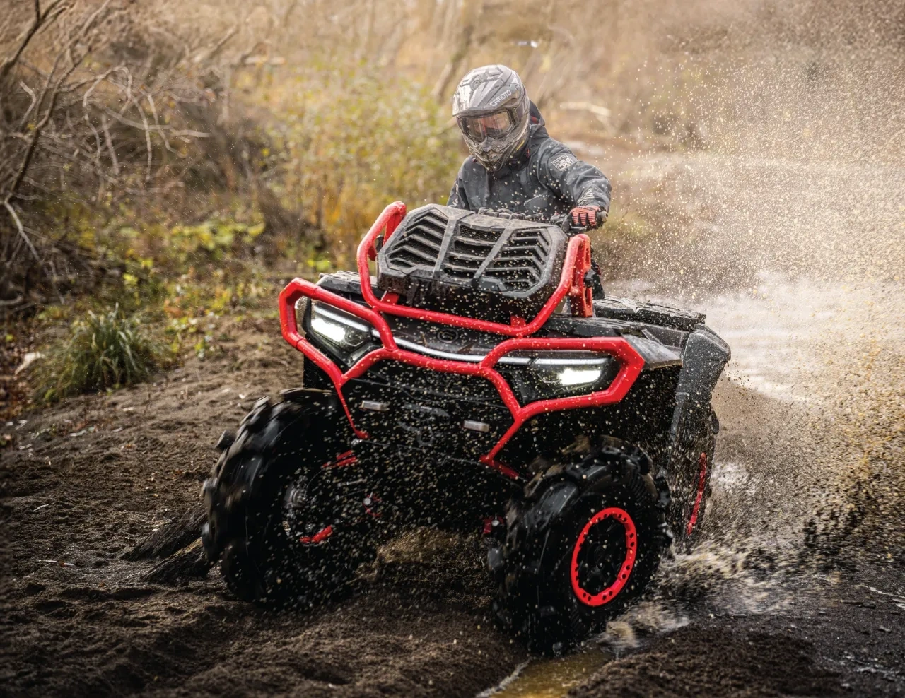 2027 CFMOTO CFORCE 1000 MV ATV with red protection equipment crossing a muddy section with a helmeted rider.