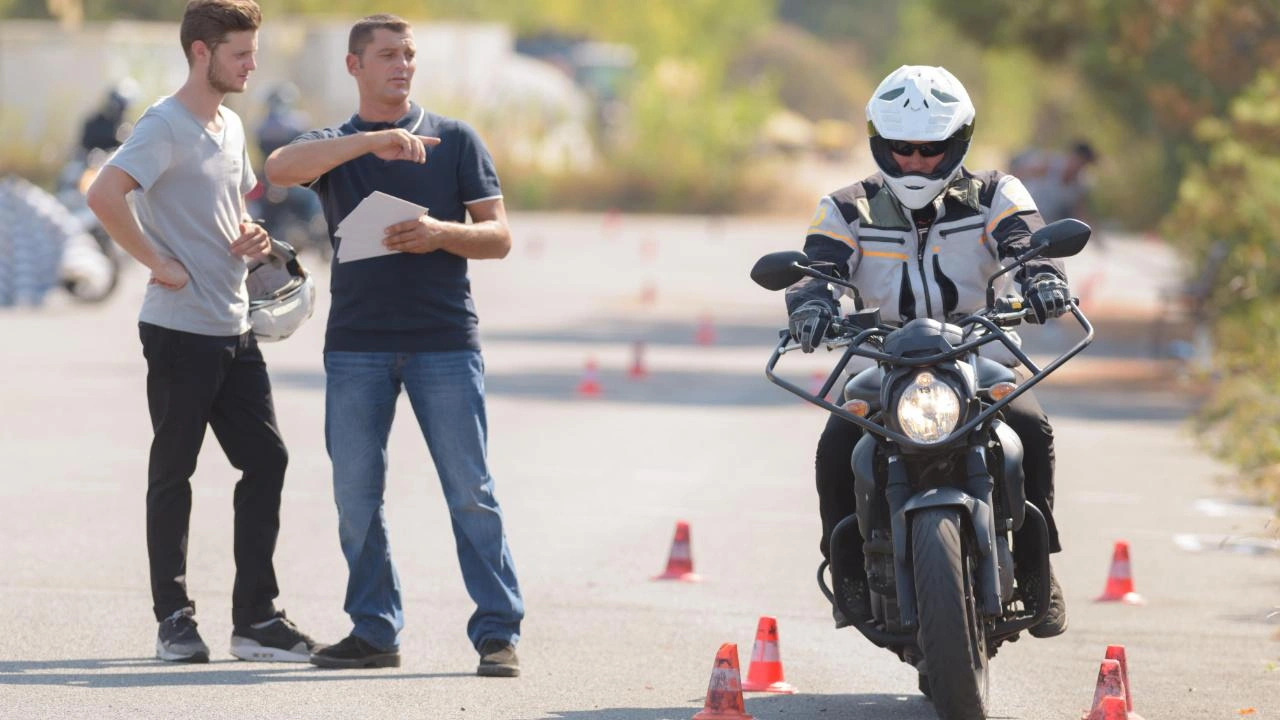 apprenti conducteur dans une école de moto près de son instructeur et un autre élève