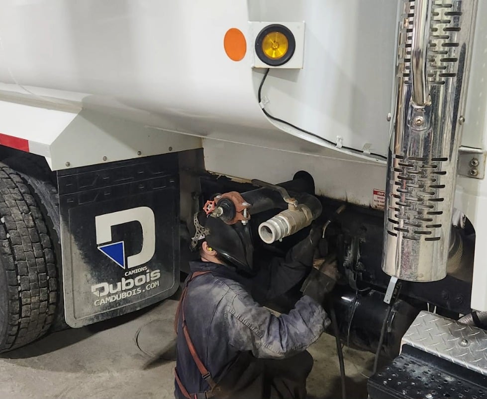 Welder working underneath a truck