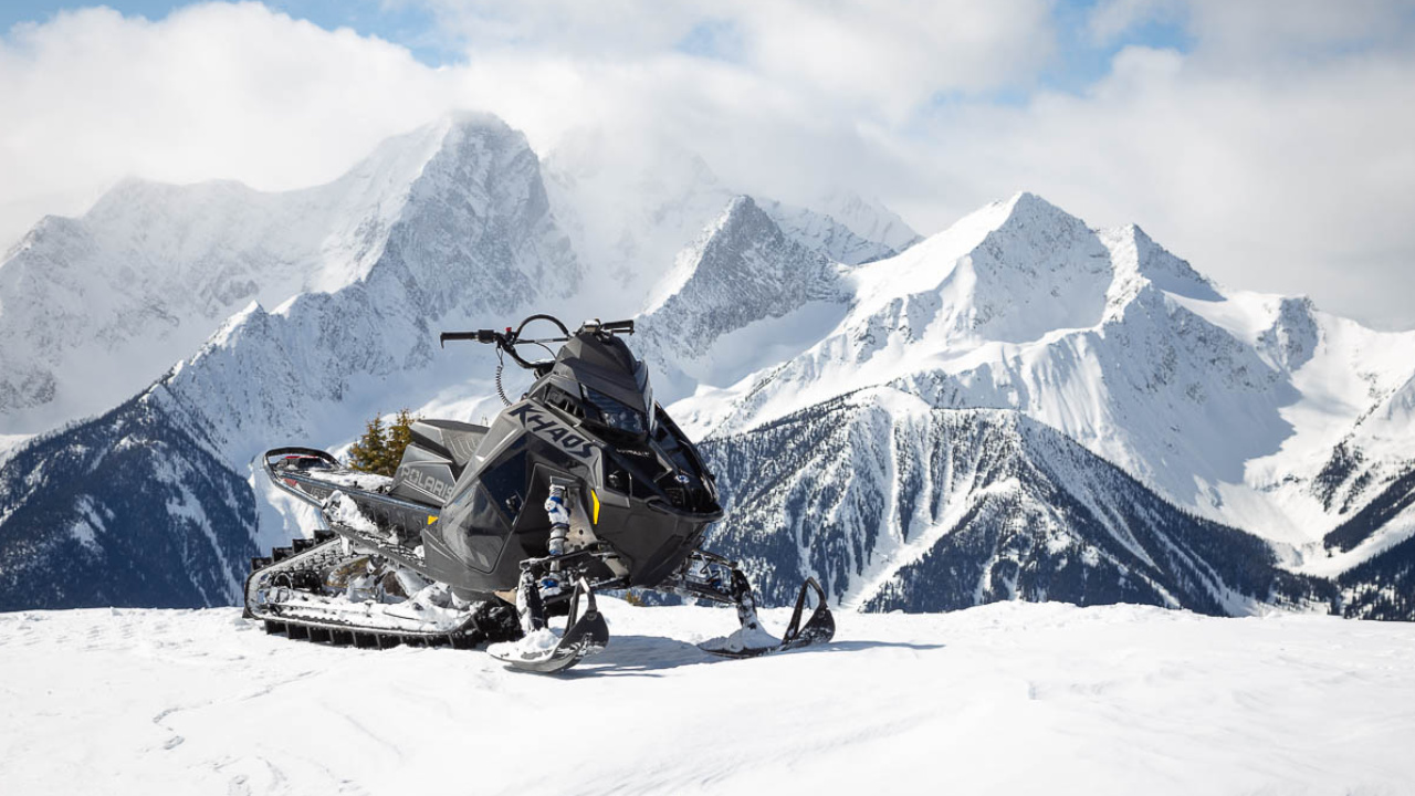 front side view of a Polaris Snowmobile on a snowy mountain