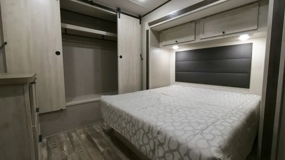 Lit queen ou King dans la chambre d'une caravane à sellette (fifth wheel) de location.