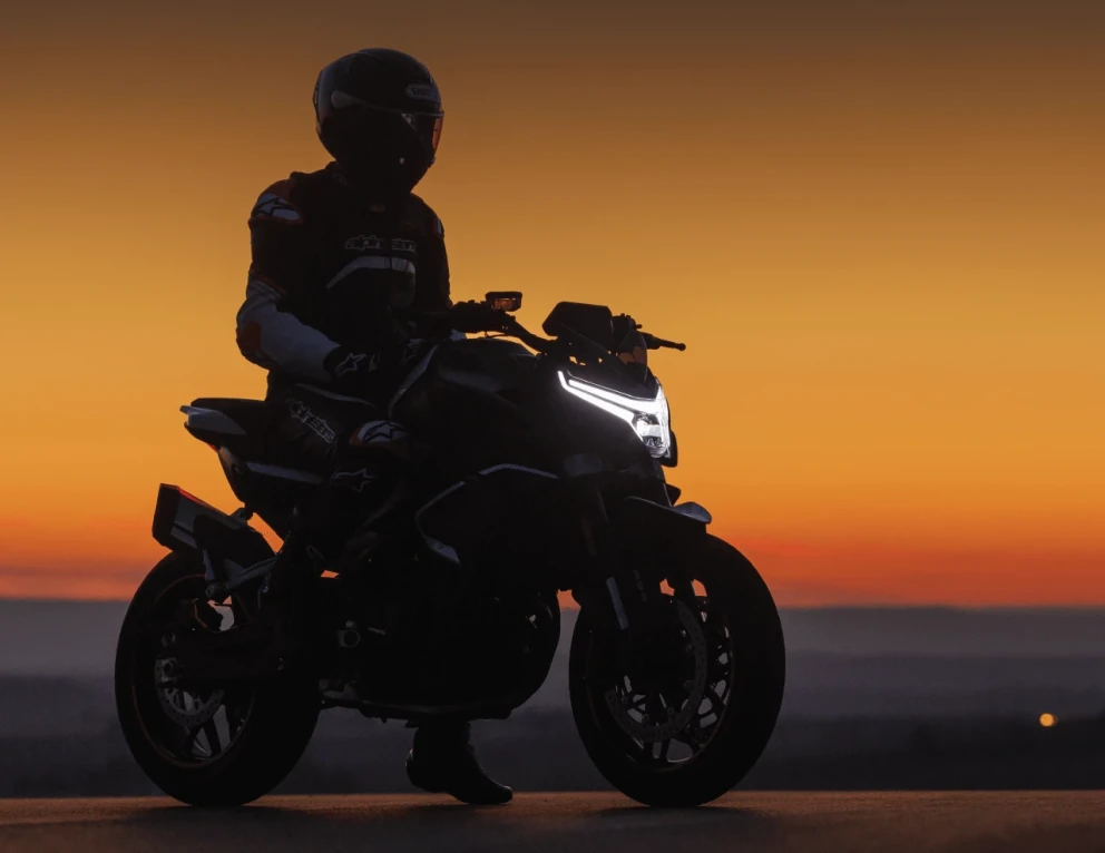 Driver of the CFMOTO 800 NK motorcycle at dusk.